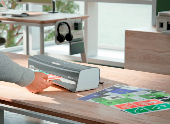 Laminointilaite käytössä toimistossa – Leitz iLAM laminoi asiakirjoja. Laminointilaite käytössä toimistossa – Leitz iLAM laminoi asiakirjoja.